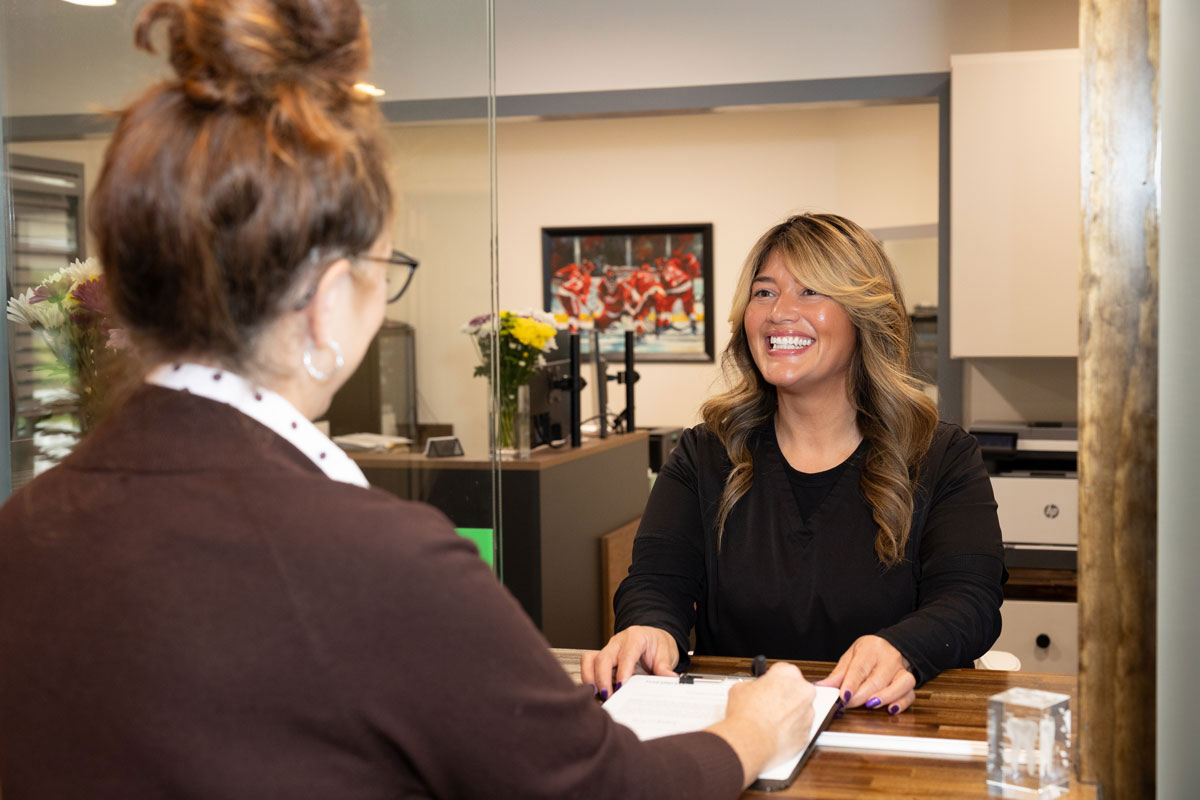 Hayden Dental Group team member helping a patient with insurance paperwork