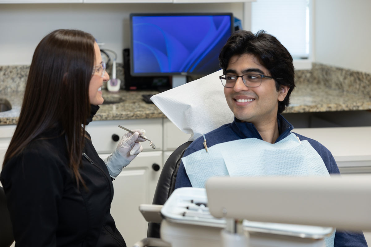 Dentist talking with a patient in a treatment room at Hayden Dental Group