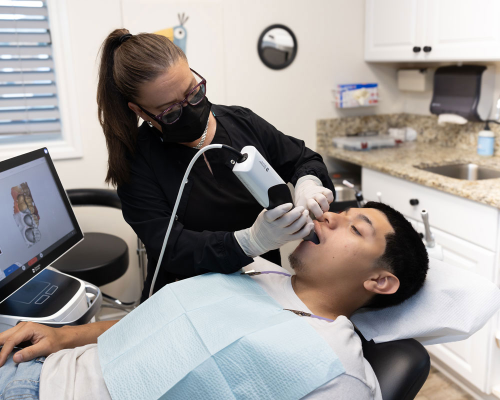 Dental team member using a digital intraoral scanner on a patient